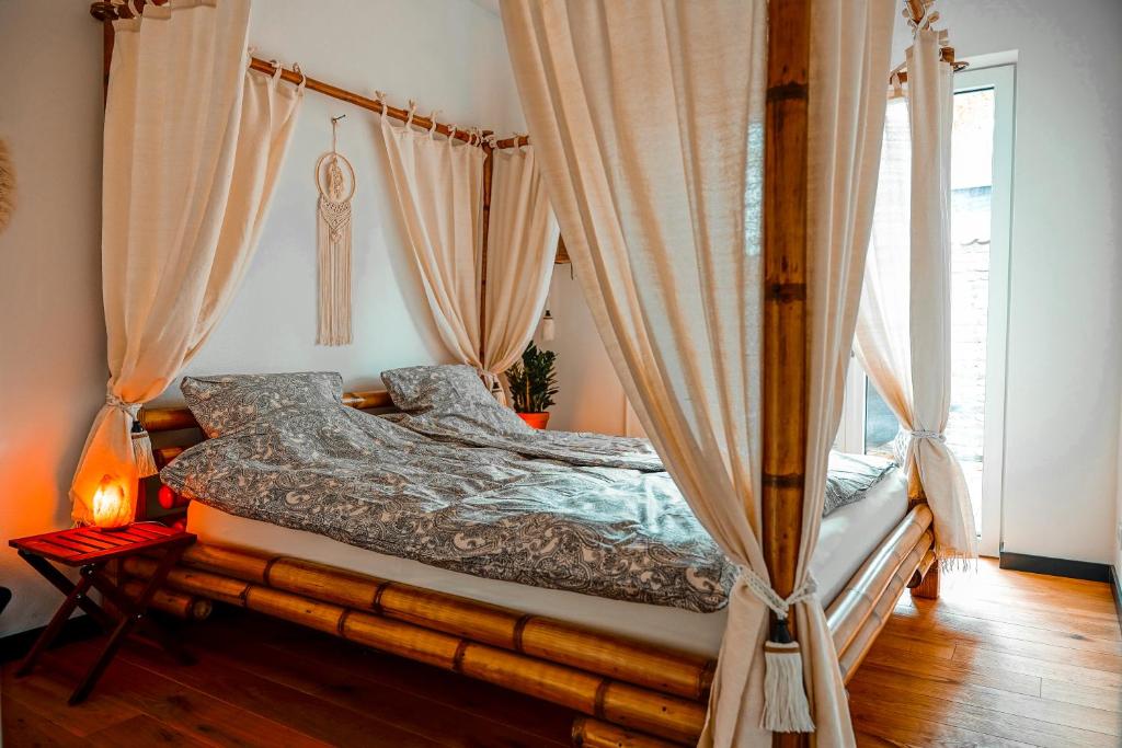 a bedroom with a canopy bed with curtains at Urban Jungle Room rundum Entspannung mit Sauna in Troisdorf