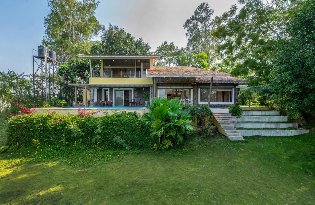 a house with stairs leading up to it at SaffronStays Sommeliers Choice in Gangāpur