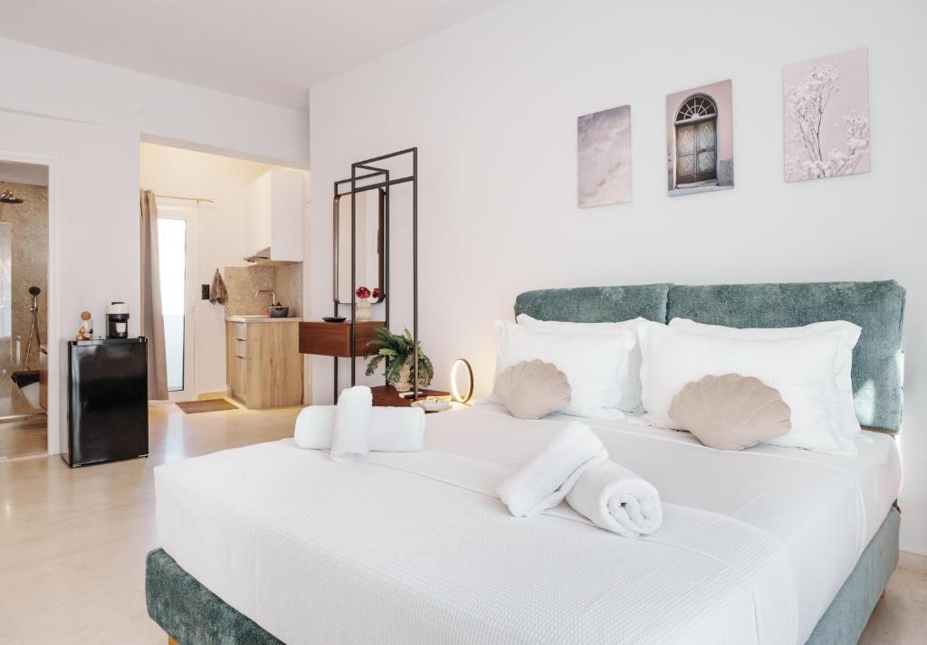 a bedroom with a large white bed with towels on it at Libyan Sea Suites in Ierápetra