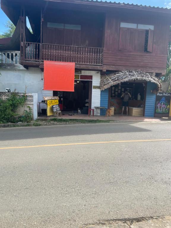 a building with a red sign on the side of the street at YPHomestay in Pai