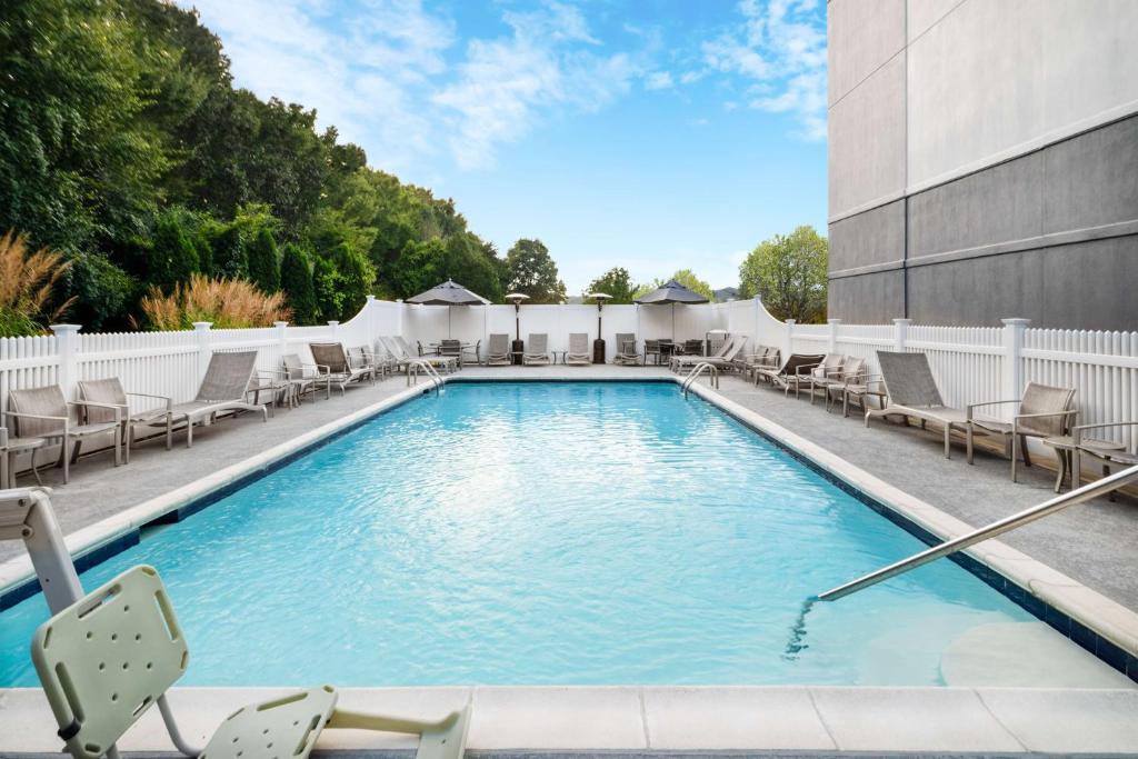 a swimming pool with lounge chairs and a building at Hyatt Place Mystic in Mystic