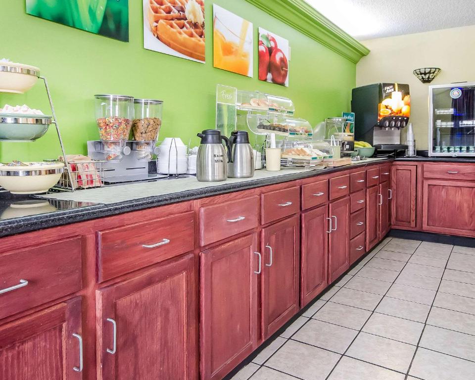 a kitchen with red wooden cabinets and a counter at Quality Inn in Franklin