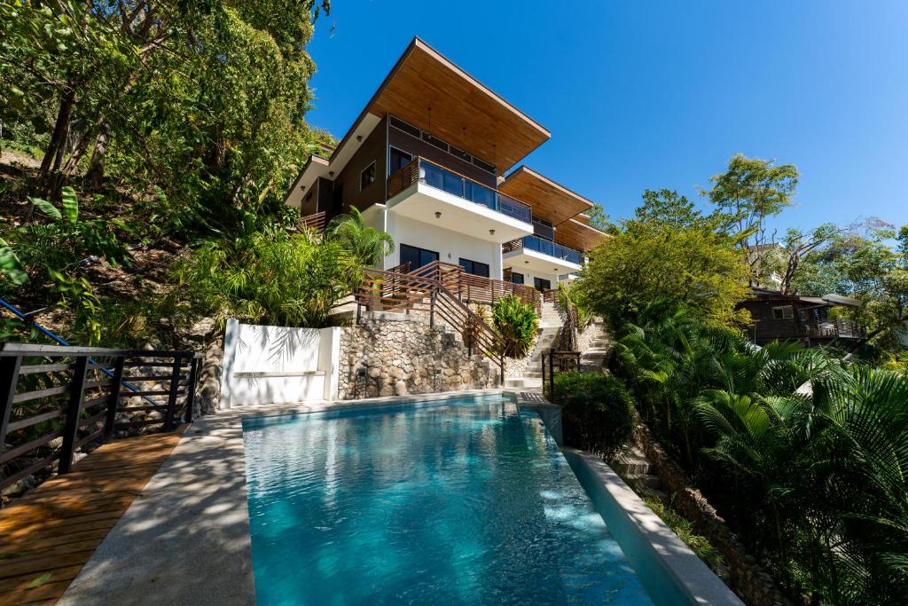 an image of a swimming pool in front of a house at Ocean Apartments- Walk to the beach in Santa Teresa Beach