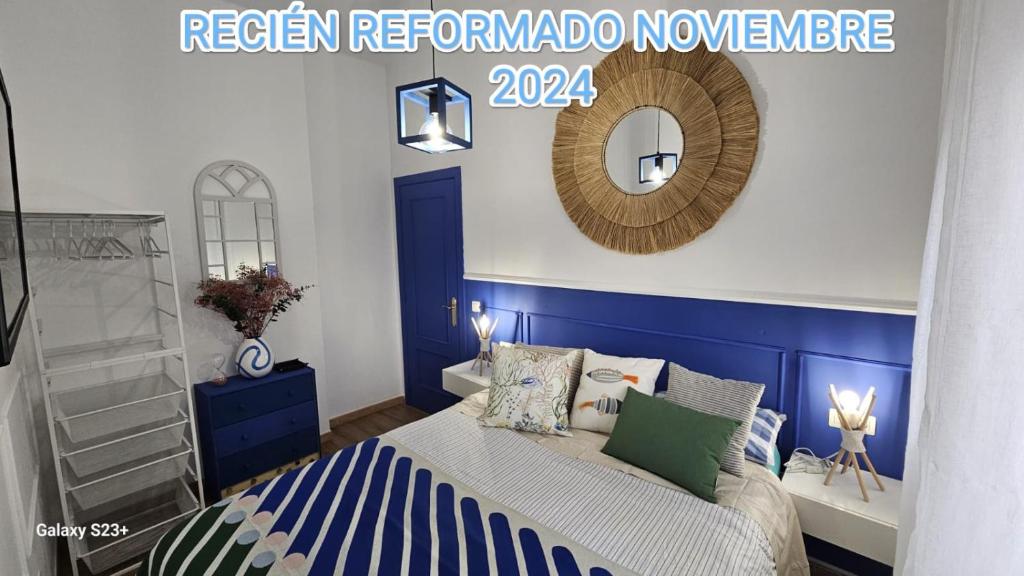 a blue and white bedroom with a bed and a mirror at Apartamento Blue Garrucha in Garrucha
