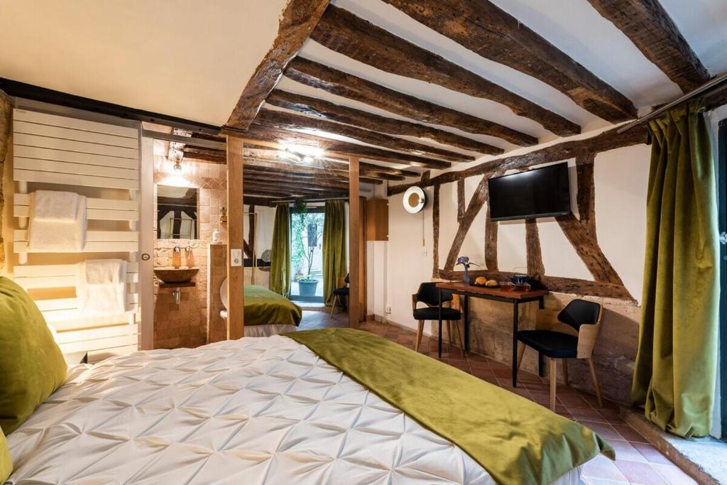 une chambre avec un lit, un bureau et une télévision dans l'établissement Charming apartment - Marais Quarter - 5P - 2BDR - Center of Paris, à Paris