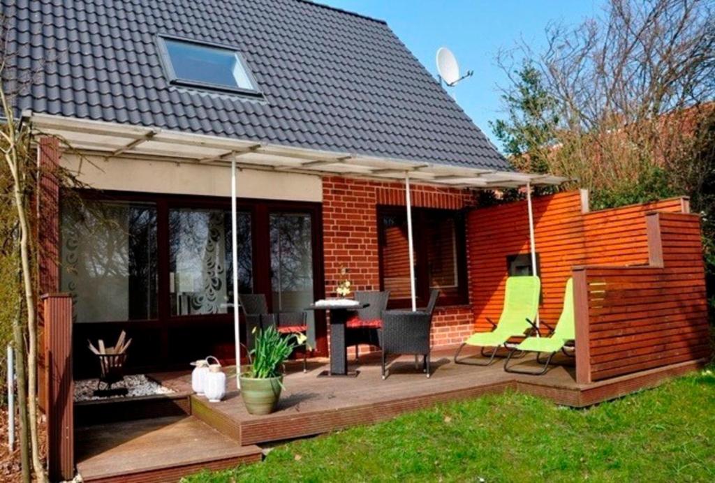 a patio with chairs and a table and a house at Ferienhaus an der Buche "Gartenblick" in Neue Tiefe Fehmarn