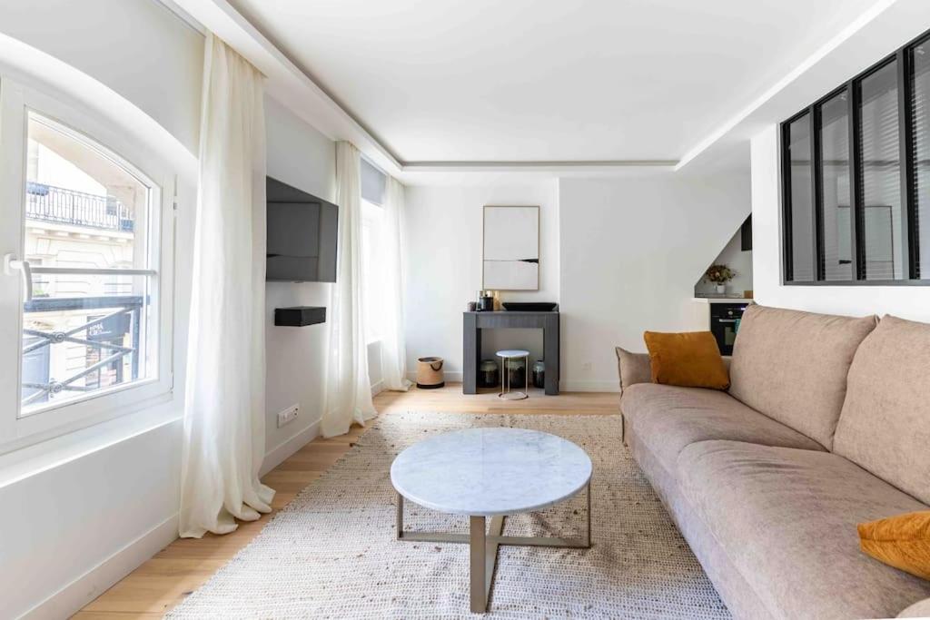 un salon avec un canapé et une table dans l'établissement Invalides Palais Bourbon Luxueux Appartement 4P, à Paris