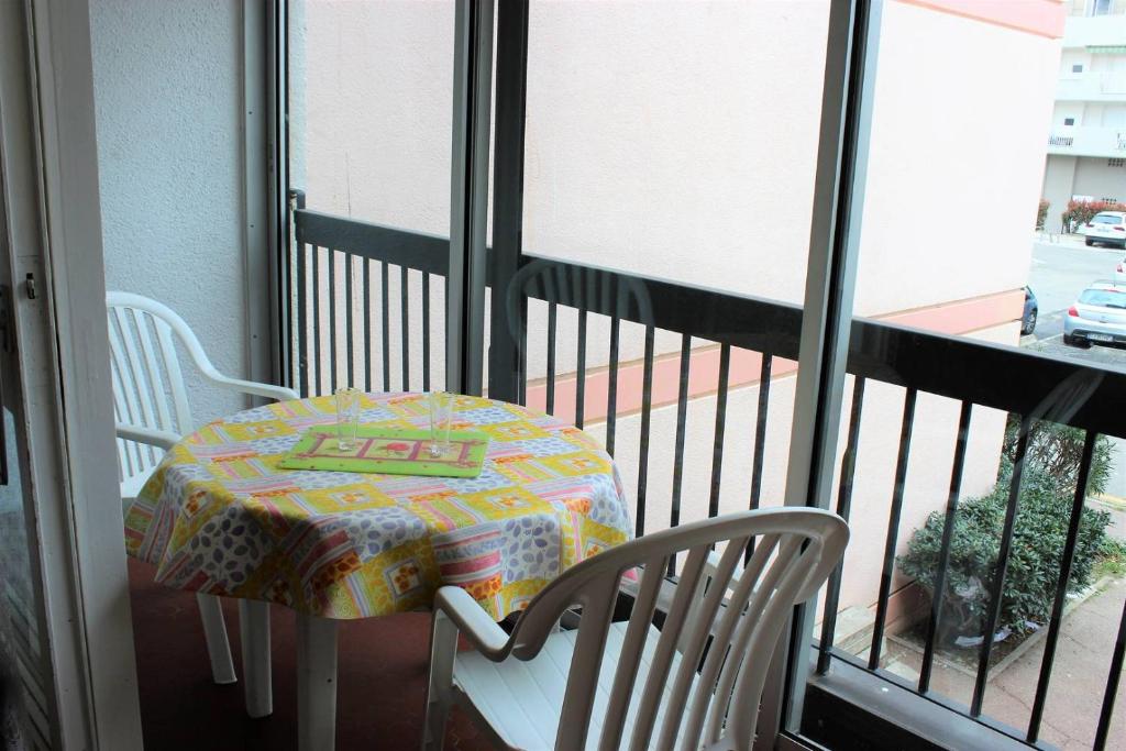 une table et une chaise sur un balcon dans l'établissement Proche du port beau T3 lumineux tout confort avec parking - 4RS121, à Saint-Cyprien