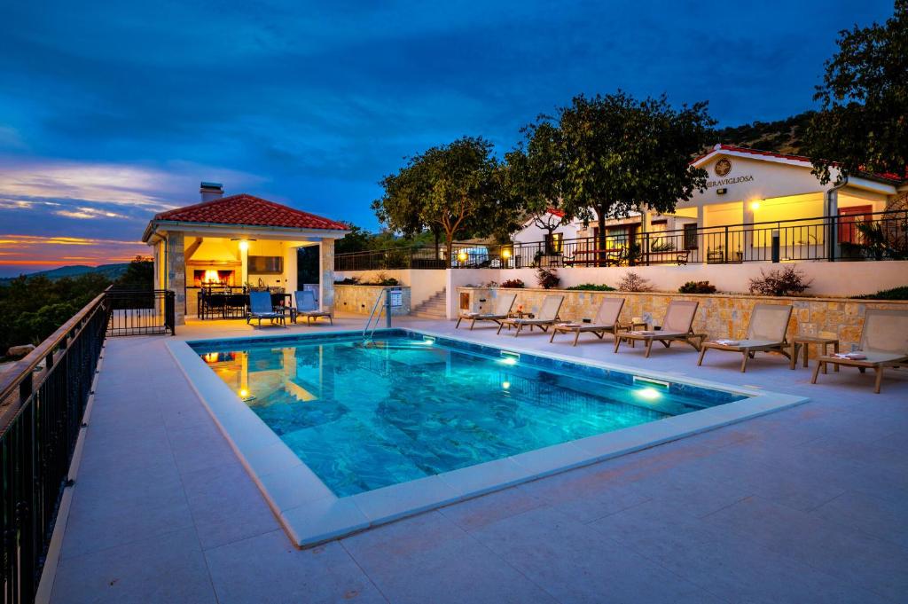 a swimming pool with chairs and a house at Villa La Meravigliosa in Vodice