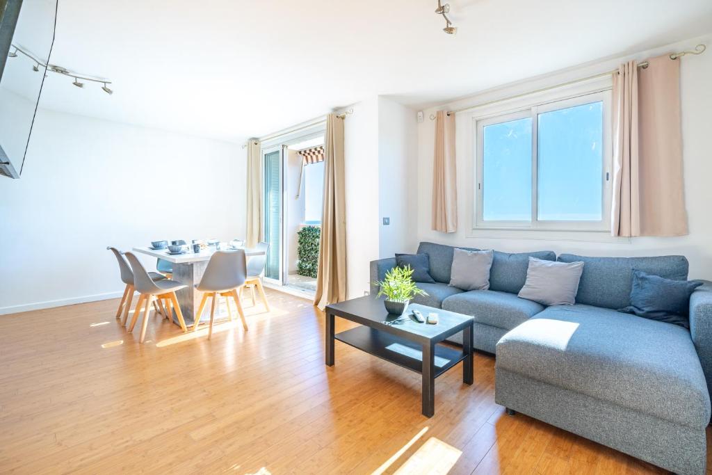 un salon avec un canapé bleu et une table dans l'établissement Superbe 3p vue mer avec parking, à Nice