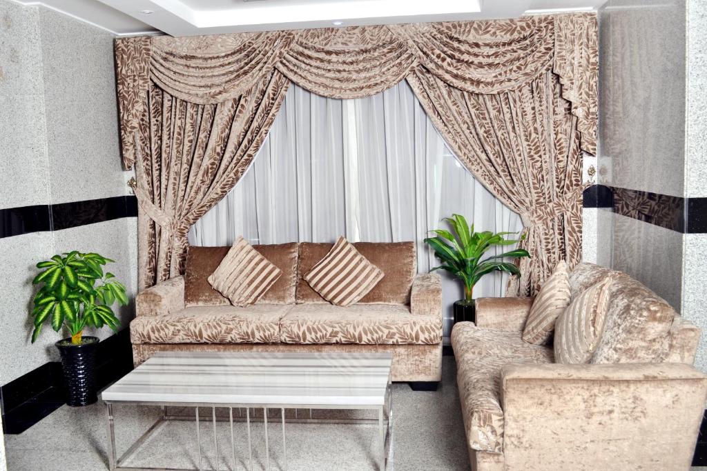 a living room with a couch and a window at Sara Hotel Apartments in Ajman 