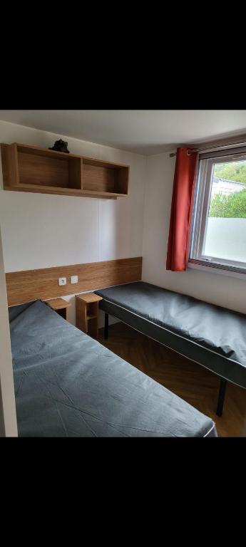 una habitación con dos camas y una ventana en Mobil home azur 74, en Fréjus