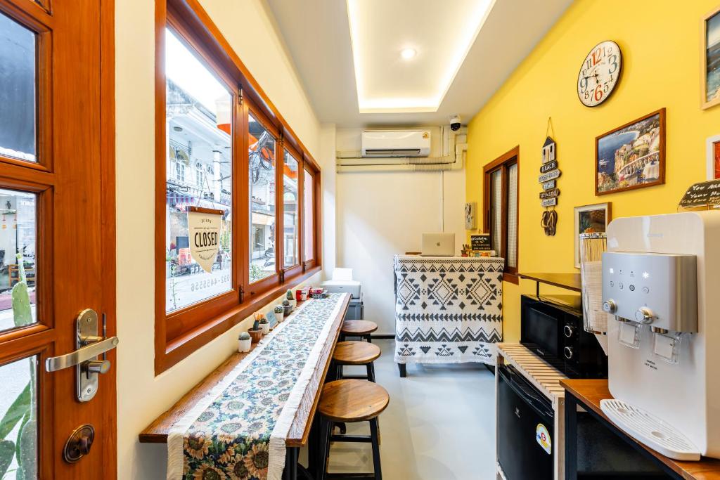 a restaurant with a counter with stools in a room at Sweett Lemon Hostel in Patong Beach