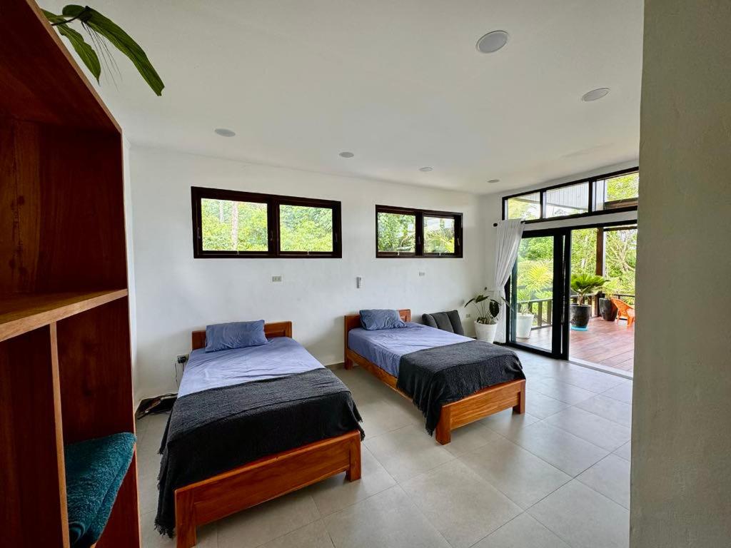 two beds in a room with windows at Villa Pandan Simeulue in Salul