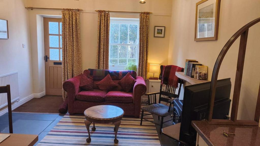Una sala de estar con un sofá y un televisor. en Cosy Cottage for two in the centre of Sedbergh, en Sedbergh