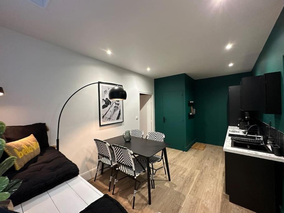 un salon avec une table et des chaises et une cuisine dans l'établissement Santa Fe, appartement neuf proche du centre-ville, à Reims