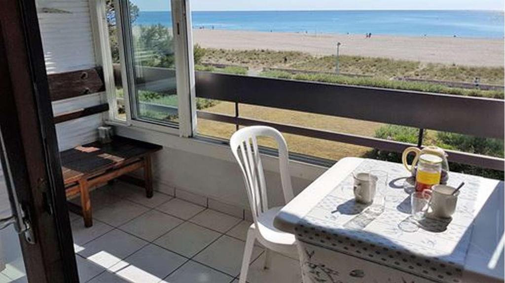 une table et des chaises sur un balcon avec vue sur la plage dans l'établissement Superbe vue pour ce joli T2 en front de mer -Wifi -Direct Plage-5PC254, à Saint Cyprien Plage