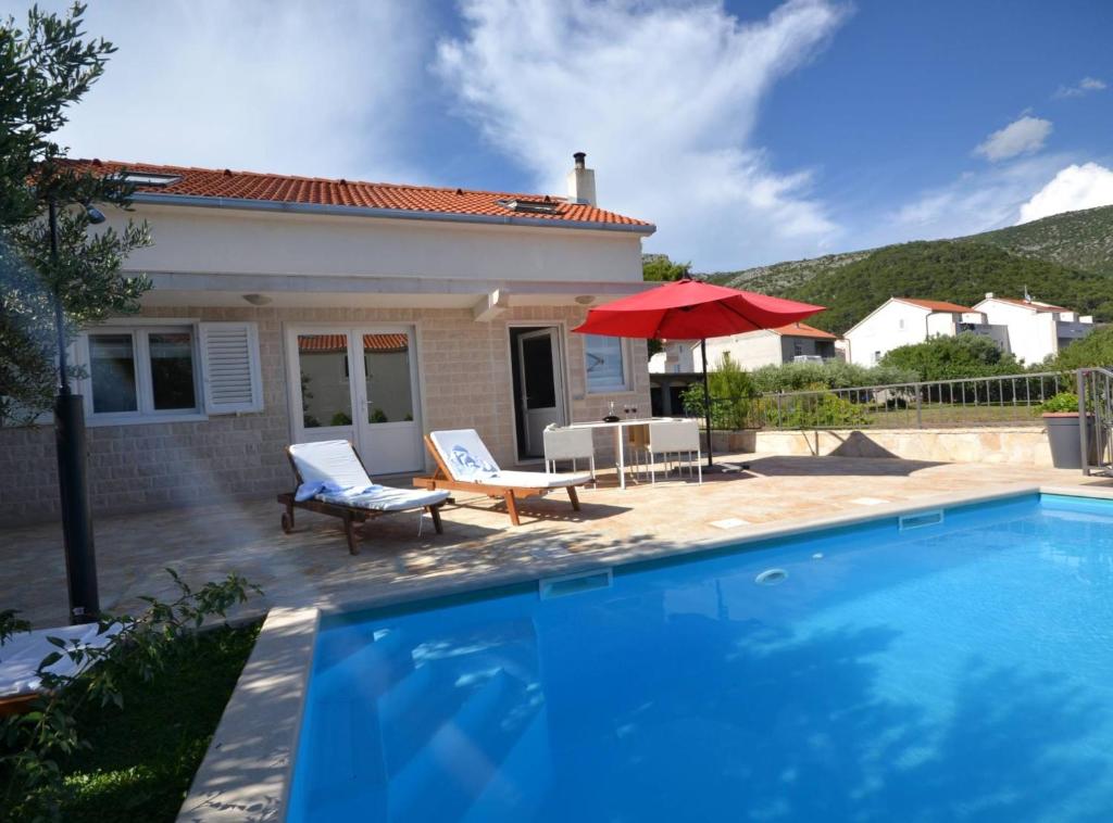 a villa with a swimming pool in front of a house at Marvelous Escape Bol Island Villa with Pool in Bol