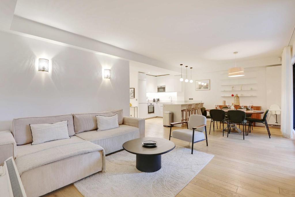 un salon avec un canapé blanc et une table dans l'établissement Passy - Eiffel Tower - Amazing 2BR with garden, à Paris