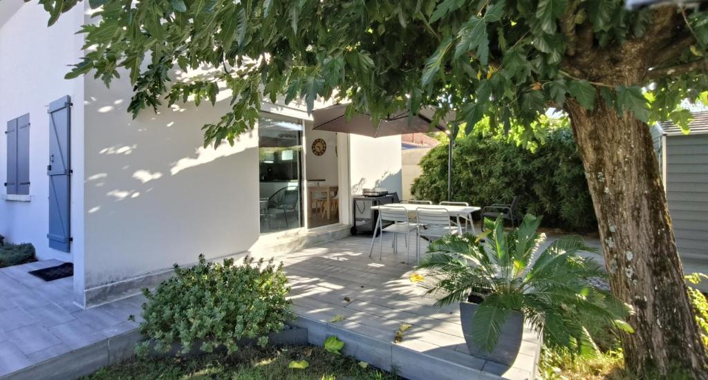 eine Terrasse mit Tisch und Sonnenschirm in der Unterkunft L escale du Bassin 800 m de la plage 3 pers in Andernos-les-Bains