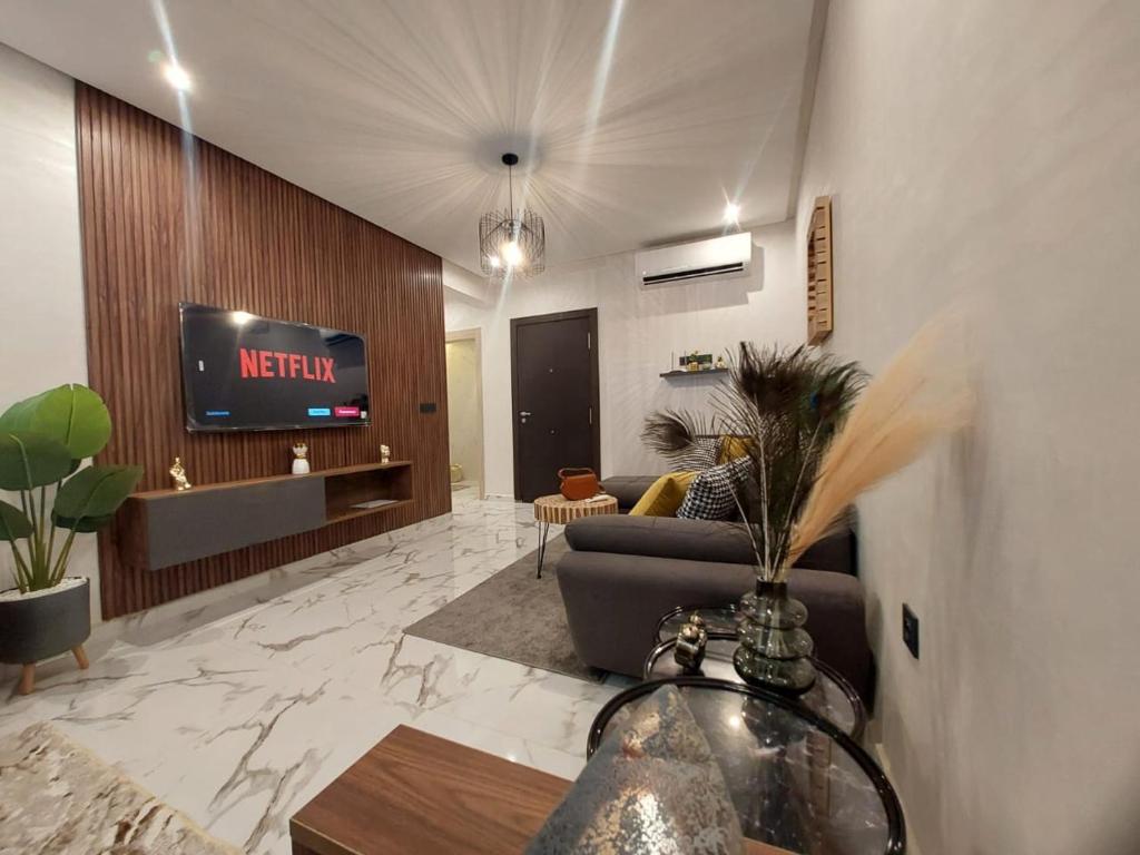 uma sala de estar com um sofá e uma TV em Palm Appart em Marraquexe