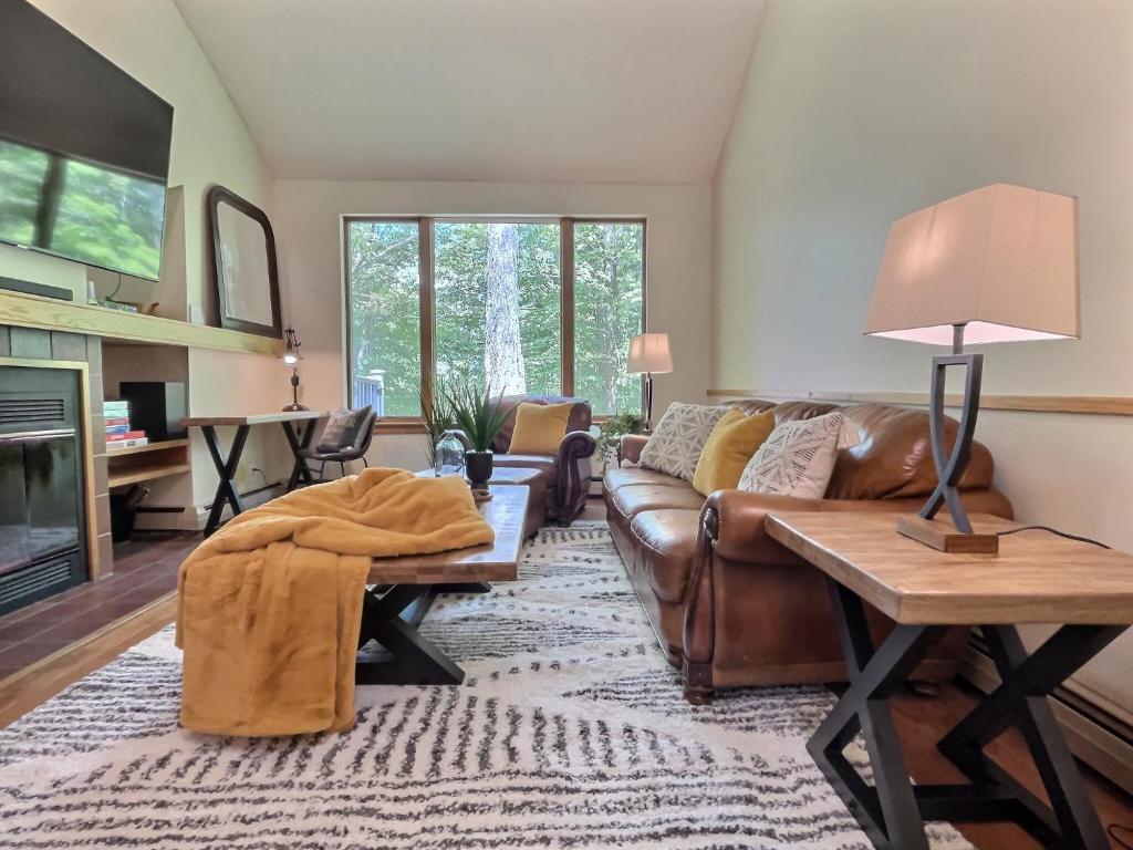 a living room with a couch and a table at SugarBear- Pool, AC, Sauna, Gym, Tennis in Killington