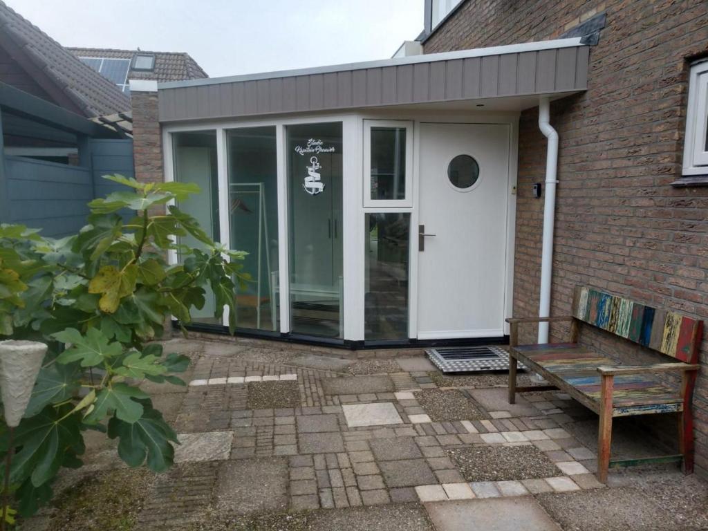 a porch with a bench in front of a house at Studio Kapitein Brouwer (2p) in Ballum