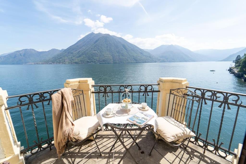 アルジェーニョにあるStorica Villa sul Lago di Como con darsena privataの水を見渡すバルコニー(テーブル、椅子付)