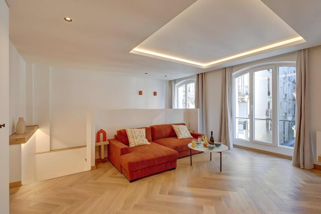un salon avec un canapé rouge et une table dans l'établissement 343 Suite Jad - Superbe Appartement à Paris, à Paris