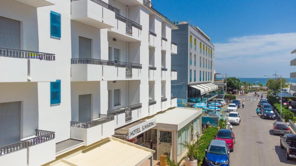 een luchtfoto van een gebouw met auto's geparkeerd op straat bij Hotel San Marino in Riccione