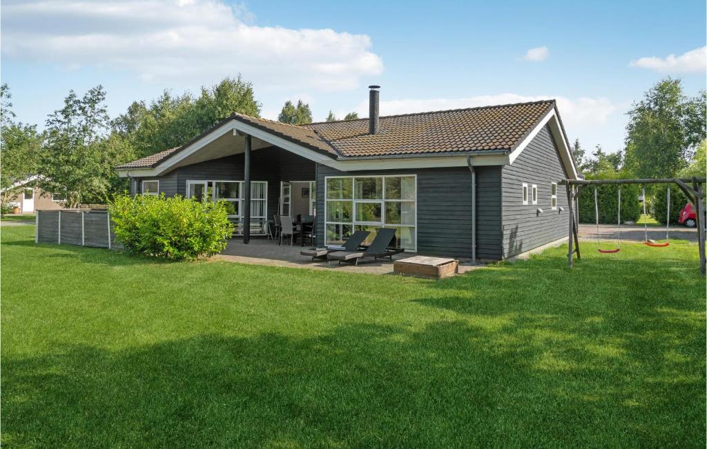 a small house with a yard with a playground at Beautiful Home In Væggerløse With Sauna in Bøtø By