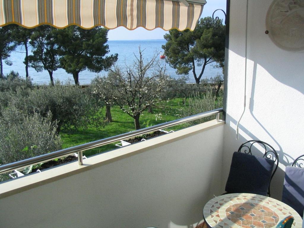 een balkon met een tafel en uitzicht op de oceaan bij Apartment Oliva with sea view in Fažana
