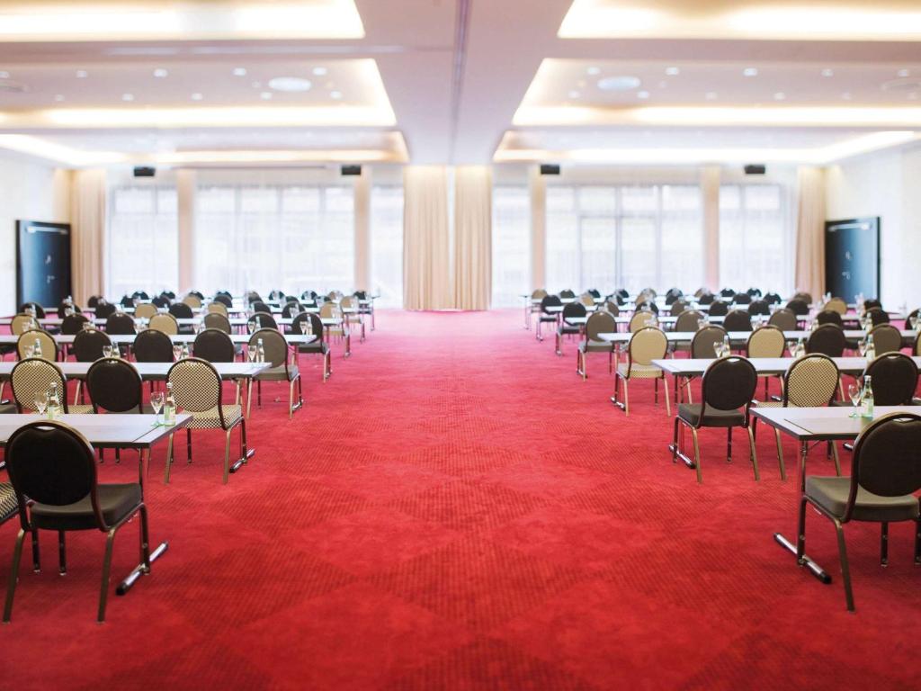 a large room with tables and chairs in it at Mövenpick Hotel Stuttgart Airport in Stuttgart