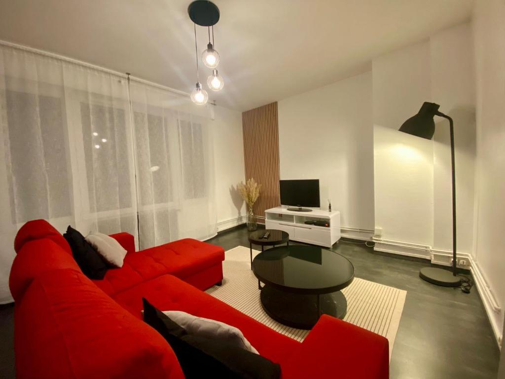un salon avec un canapé rouge et une table dans l'établissement Un coin de paradis - 355, à Rouen