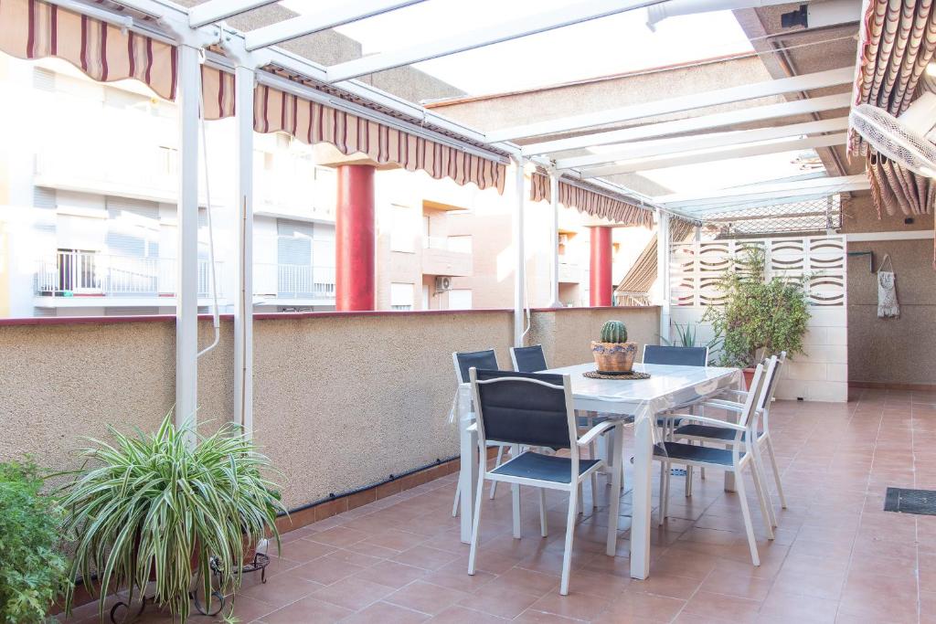 an outdoor patio with a white table and chairs at Global Properties, Apartamento muy cerca de la playa de Puerto de Sagunto in Puerto de Sagunto