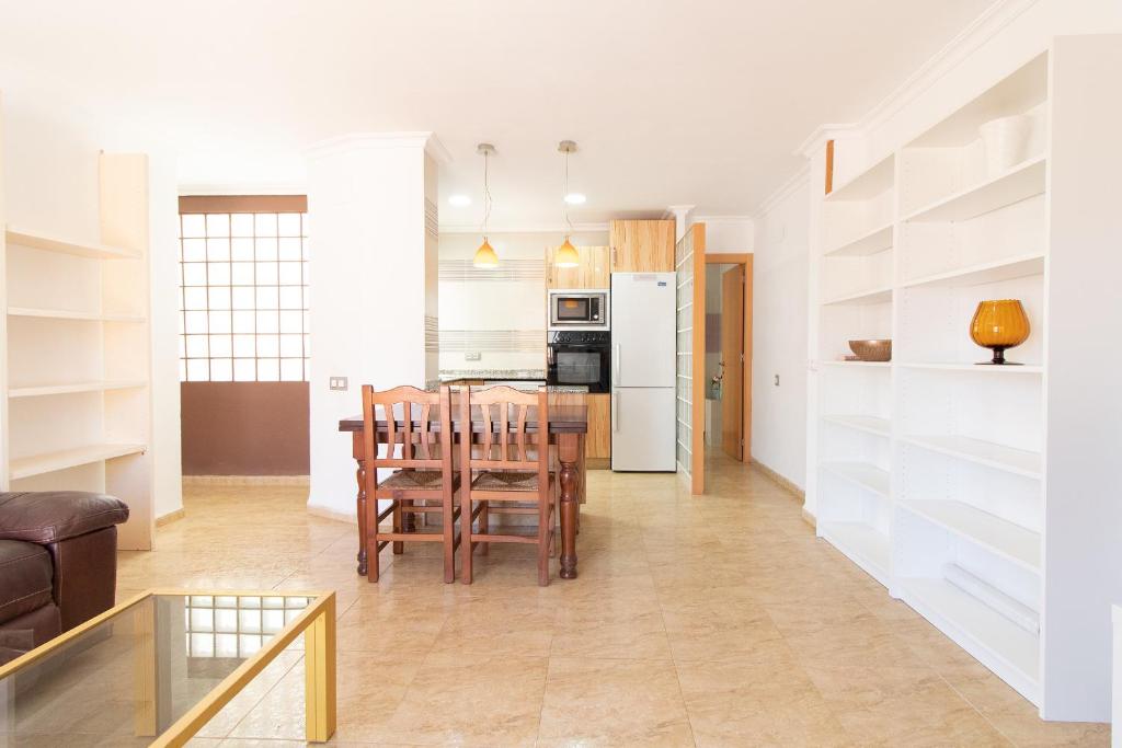 a kitchen and living room with a table and chairs at Global Properties, Apartamento con terraza en la playa de Puerto Sagunto in Puerto de Sagunto