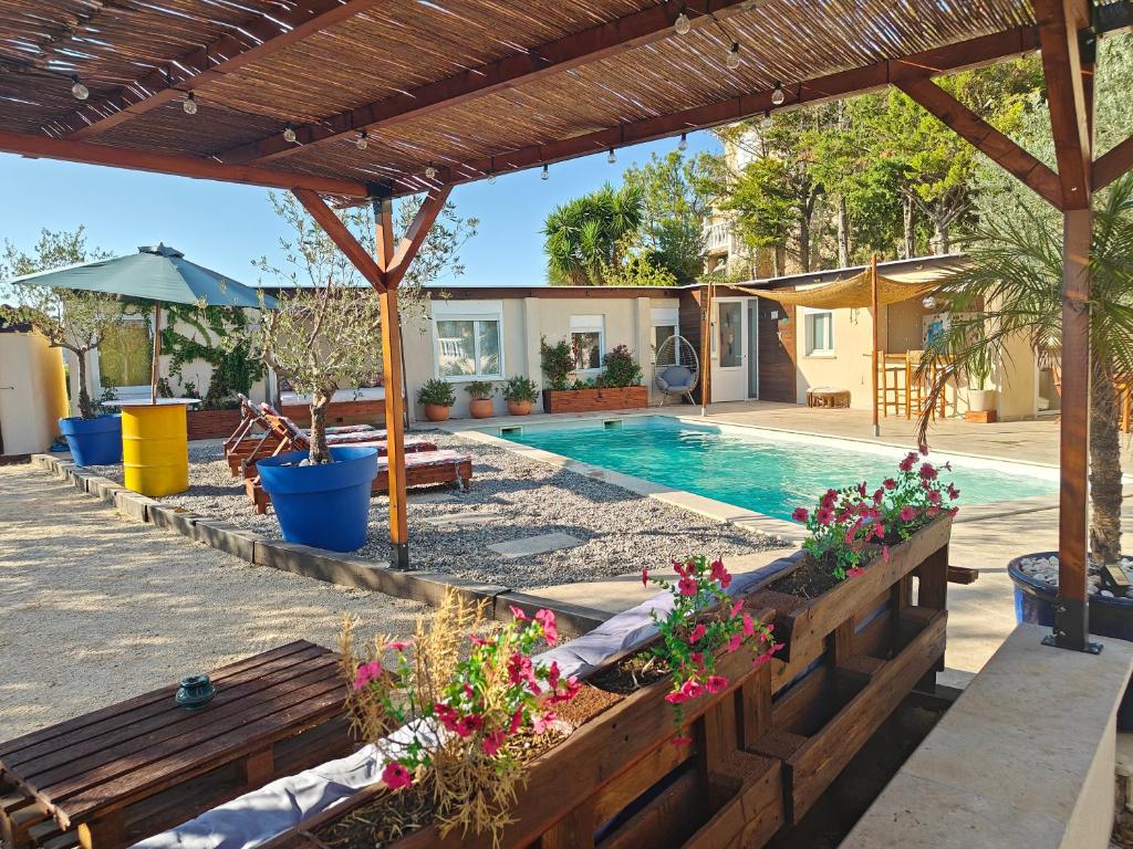 une cour avec une piscine et une pergola en bois dans l'établissement Casa Viajano - Dépendance Villa Marseille, à Marseille