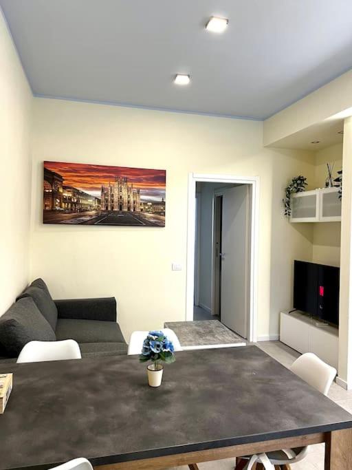 een woonkamer met een tafel en een bank bij 10 min da Navigli e centro, nuova e luminosa oasi 1p in Milaan