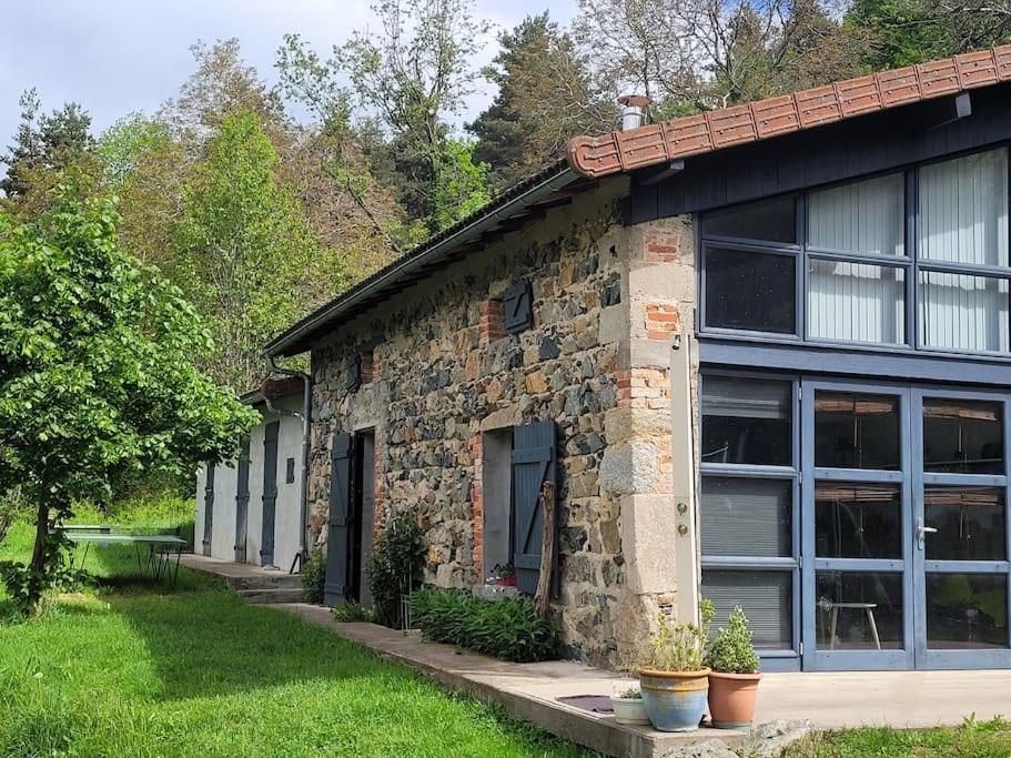 un bâtiment en pierre avec des fenêtres et des plantes devant lui dans l'établissement Loft Via Nova 4 pers 65 m2, à Lavoine