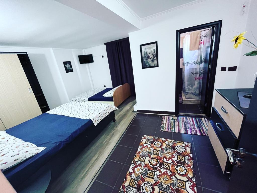 a hotel room with two beds and a rug at Vila Khalo in Mangalia
