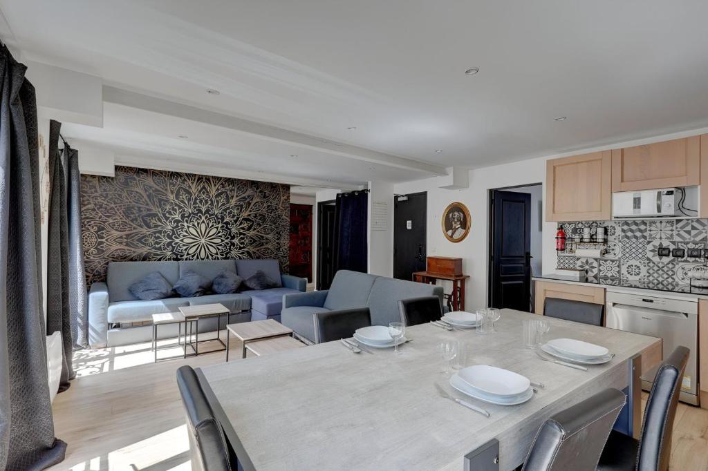 une cuisine et un salon avec une table et un canapé dans l'établissement Bluestay 130 - Charmant appartement à Paris 2, à Paris