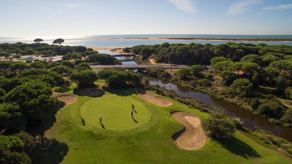 an overhead view of a golf course next to a river at Hotel Nuevo Portil Golf in El Rompido