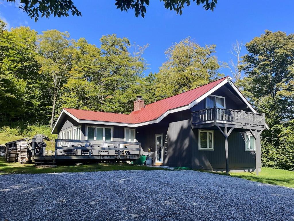 a house with a red roof and a driveway at Alpine Chalet Grill, Fire pit, Pool, Gym, CornHole in Killington