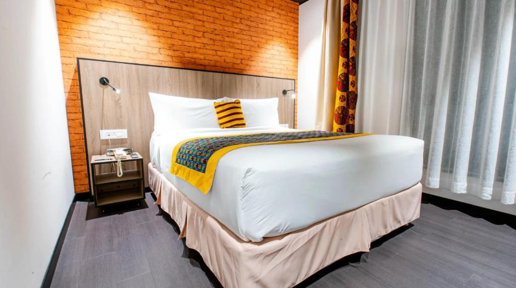 Postel nebo postele na pokoji v ubytování ONOMO Hotel Kampala