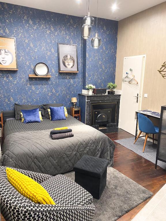- une chambre avec un lit, une chaise et une cheminée dans l'établissement Studio chic & romantique, à Caluire-et-Cuire