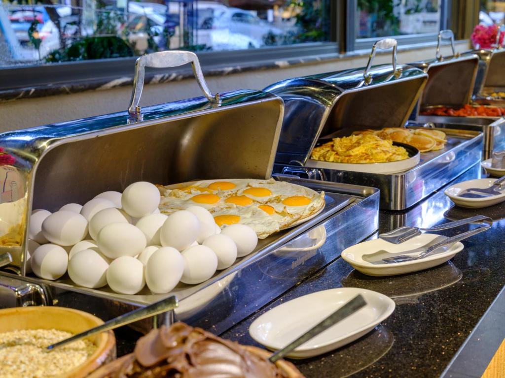 a buffet line with eggs and other breakfast foods at Aria Riva Apart Hotel in Alanya
