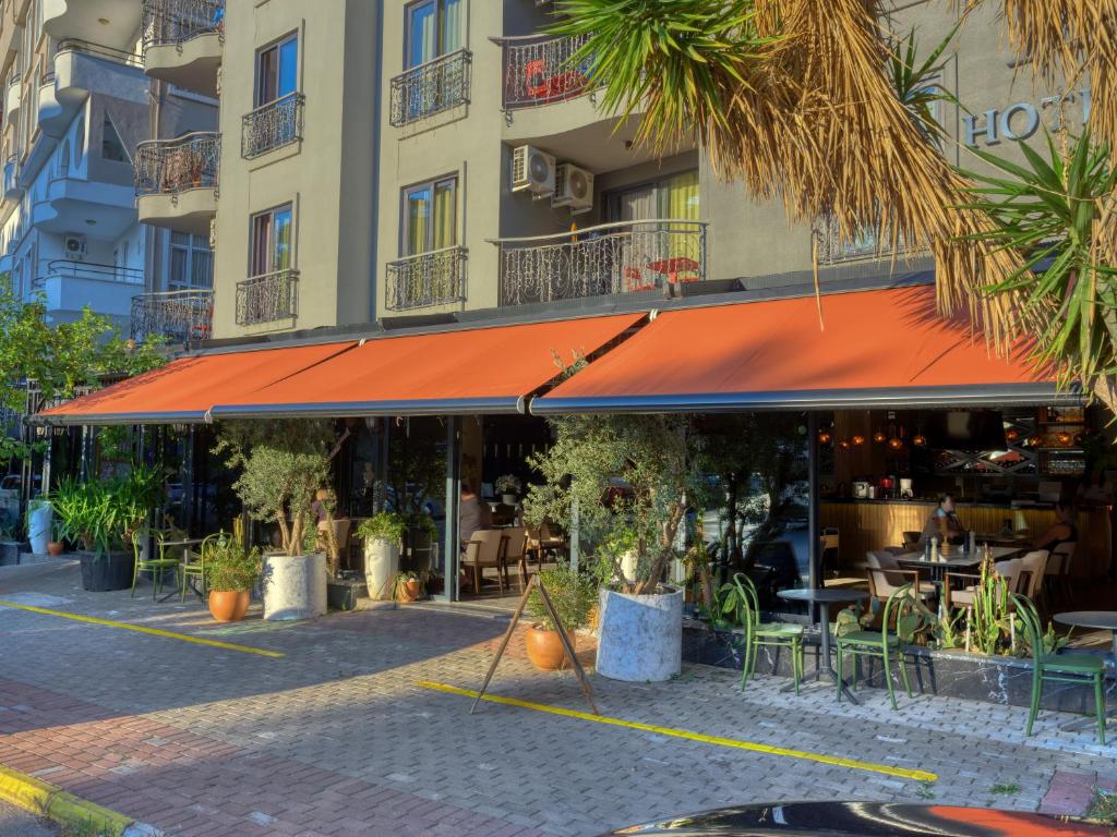 a restaurant with an orange awning in front of a building at Aria Riva Apart Hotel in Alanya