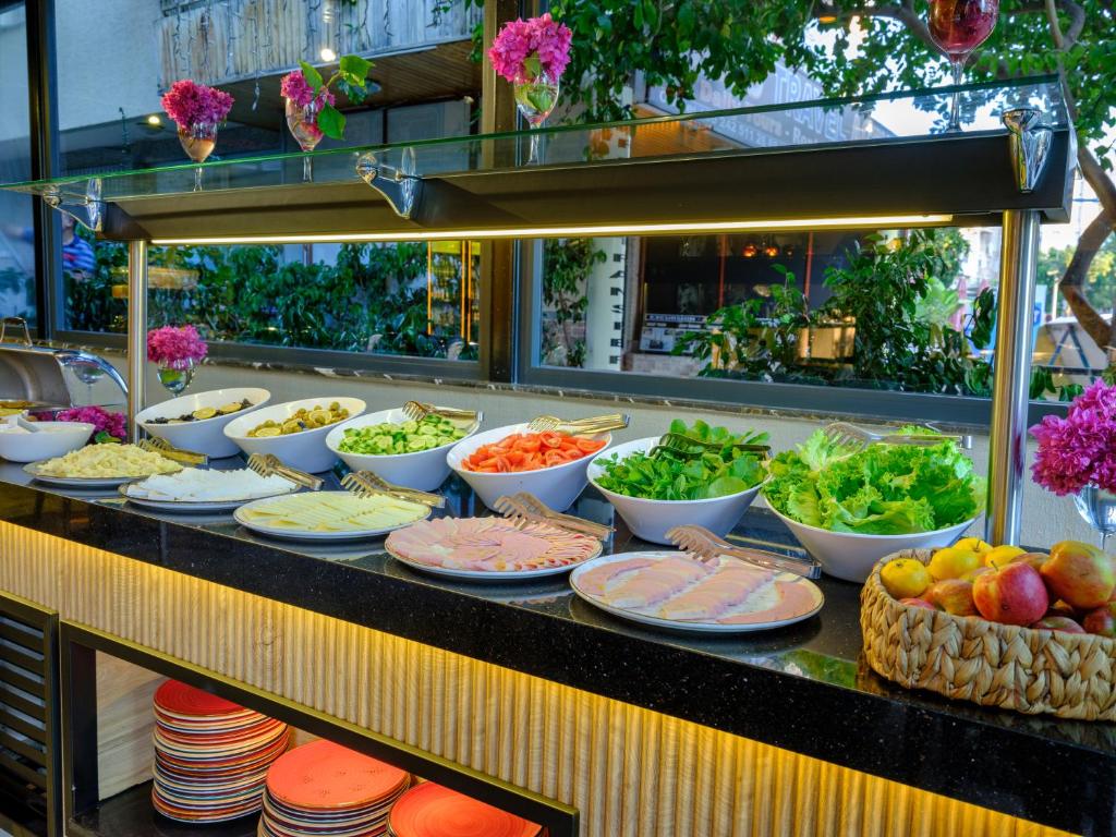 a buffet line with bowls and plates of food at Aria Riva Apart Hotel in Alanya