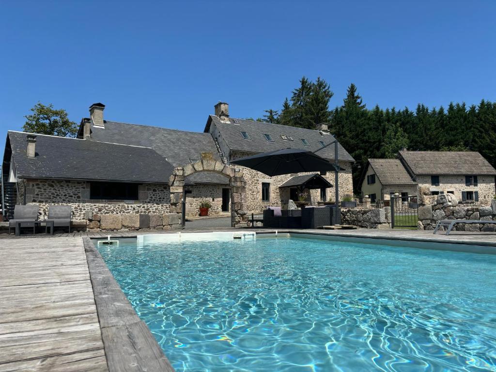 a large swimming pool in front of a house at Domaine des Annouillards in Sornac