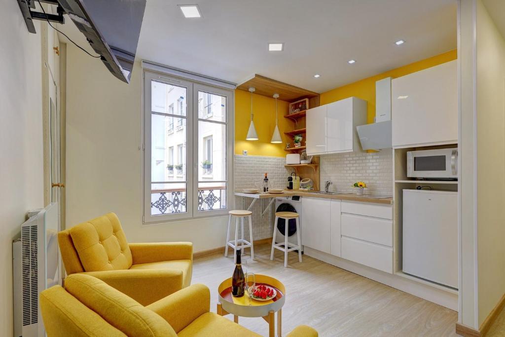 une cuisine avec un canapé, une chaise et une table dans l'établissement 408 Suite Montorgueil - Superbe Studio à Paris, à Paris